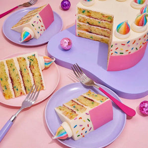 Birthday Cake by Crumbs & Doilies with confetti sponge, vanilla buttercream, rainbow sprinkles, and unicorn meringue.